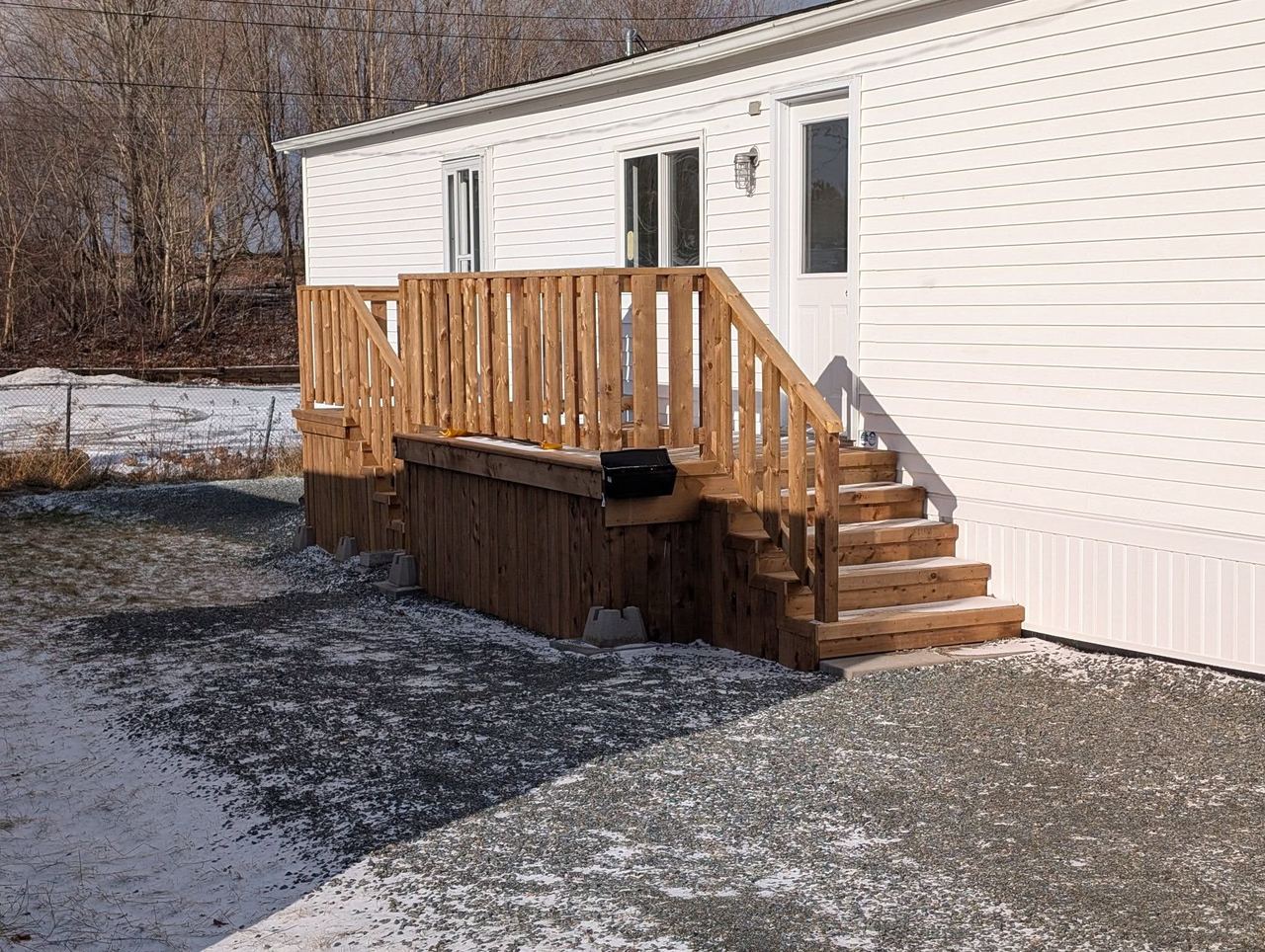 Newly built wooden wheelchair ramp with a turning landing and handrails on both sides, Maitland, Nova Scotia.